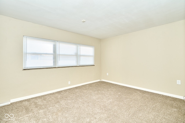 carpeted spare room with baseboards