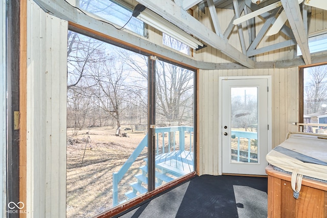 doorway to outside with lofted ceiling and a sunroom