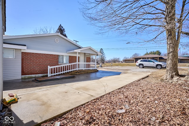 exterior space with concrete driveway and brick siding