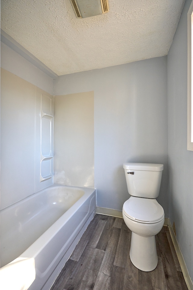 bathroom with visible vents, a textured ceiling, toilet, and wood finished floors