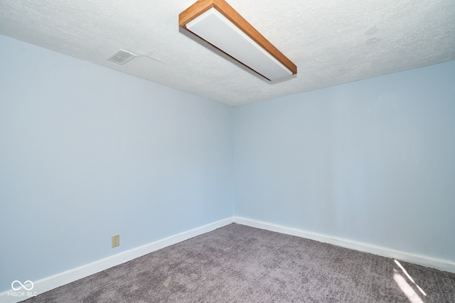 spare room with carpet flooring, visible vents, and baseboards