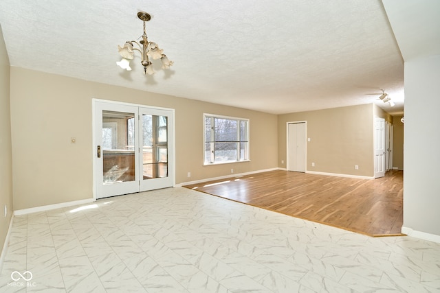 unfurnished room featuring baseboards, a notable chandelier, and marble finish floor