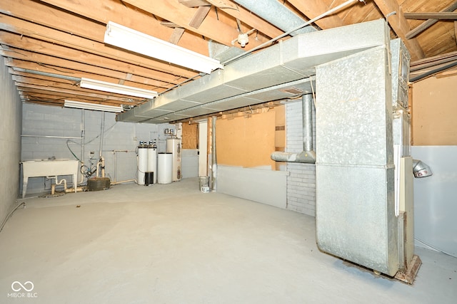 unfinished basement featuring heating unit, water heater, and a sink