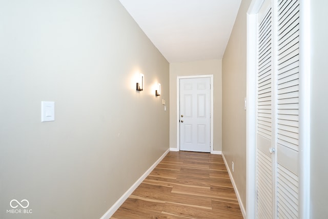 corridor with light wood finished floors and baseboards