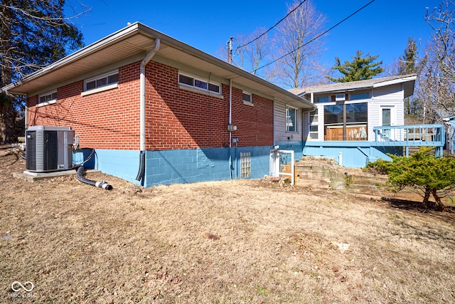 view of side of property featuring central air condition unit and brick siding