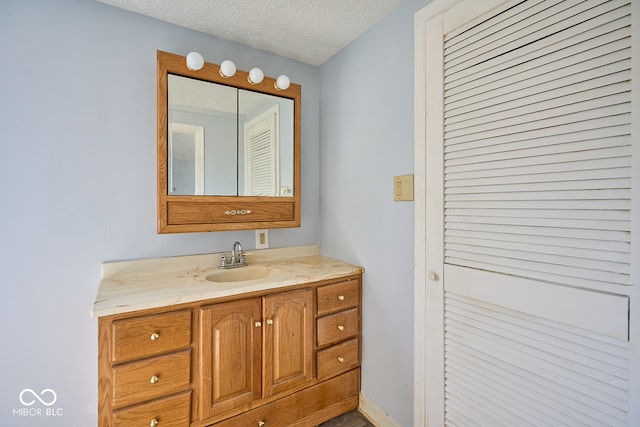 bathroom with a textured ceiling and vanity