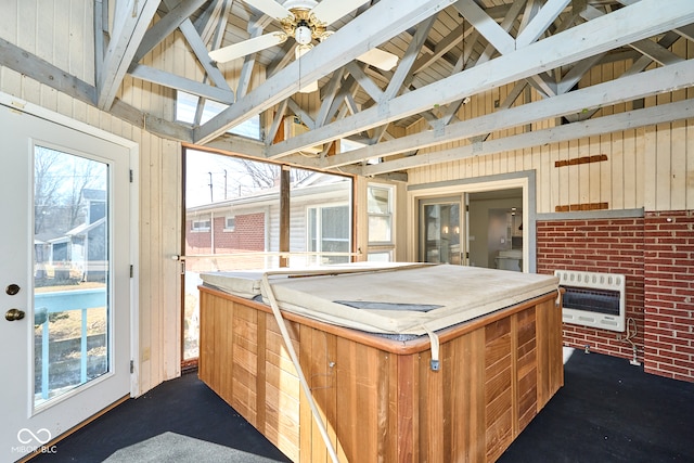 kitchen with heating unit, beam ceiling, wood walls, and a ceiling fan