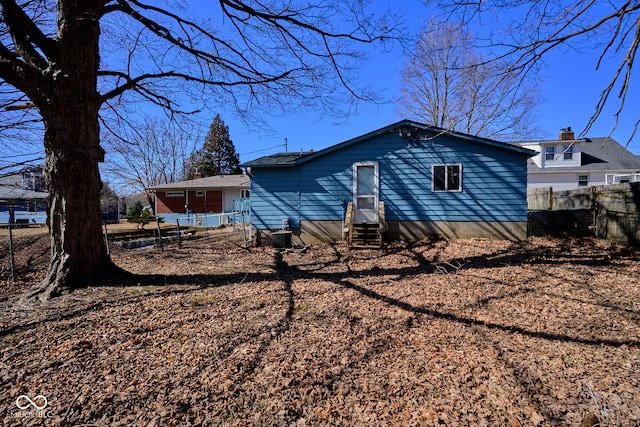 rear view of property featuring fence, central AC, and entry steps