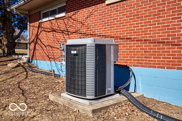 details featuring cooling unit and brick siding