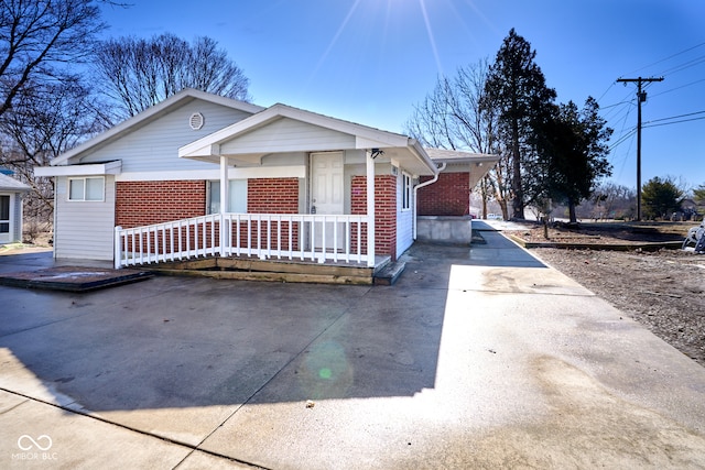 view of front facade featuring brick siding and covered porch