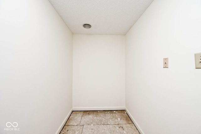 spare room featuring baseboards and a textured ceiling