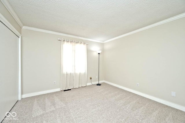 empty room with a textured ceiling, baseboards, carpet floors, and ornamental molding