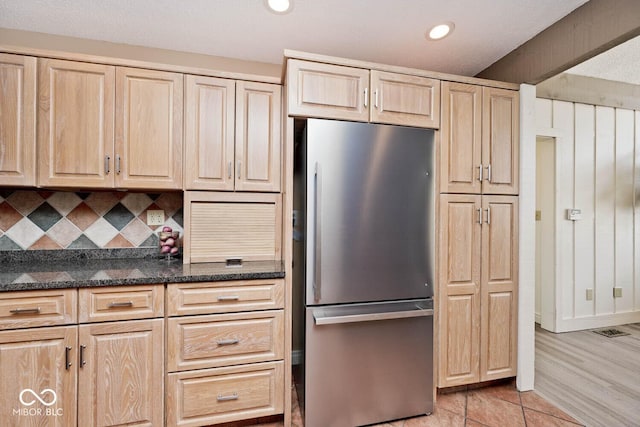 kitchen featuring light brown cabinetry, recessed lighting, backsplash, and freestanding refrigerator