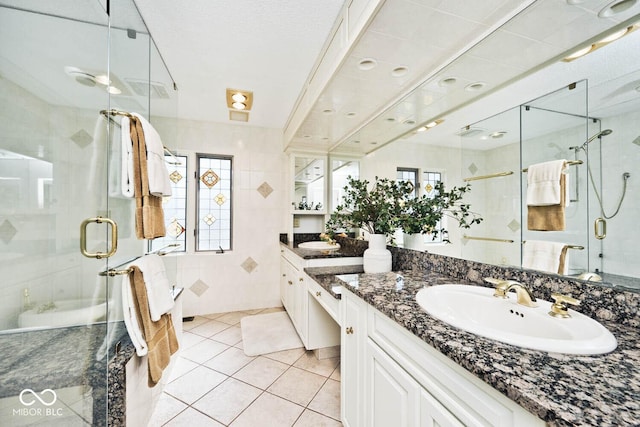 bathroom featuring tile walls, a stall shower, vanity, and tile patterned flooring