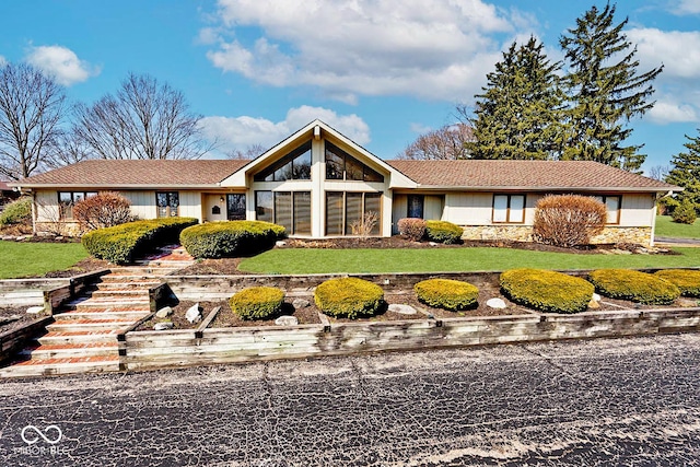 view of front of house with stone siding and a front yard