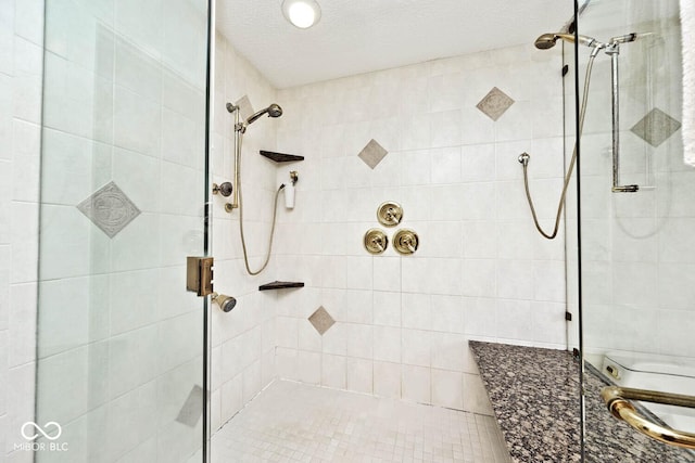 full bath featuring a shower stall and a textured ceiling