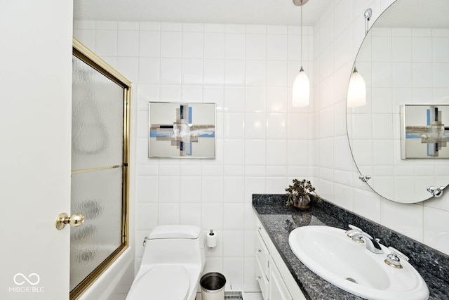 full bathroom featuring enclosed tub / shower combo, toilet, tile walls, and vanity