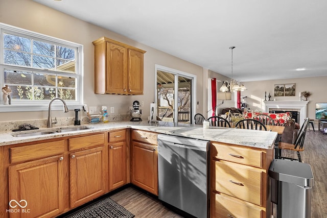 kitchen featuring open floor plan, dishwasher, a fireplace, a peninsula, and a sink