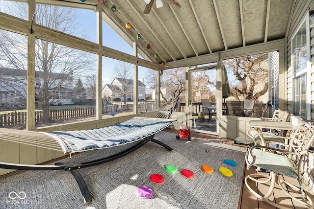 sunroom / solarium featuring a wealth of natural light, lofted ceiling, and a ceiling fan