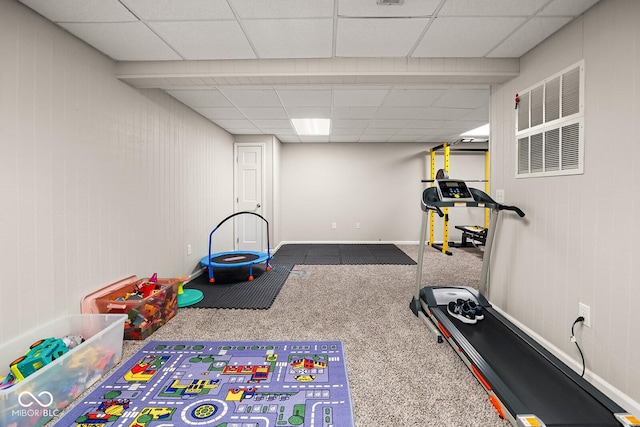 workout room with visible vents, a paneled ceiling, and baseboards