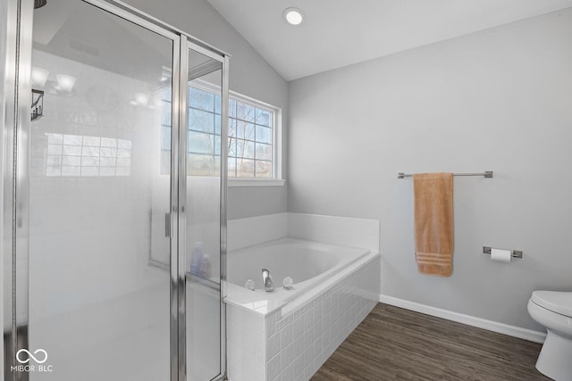 bathroom with a bath, wood finished floors, lofted ceiling, a stall shower, and toilet