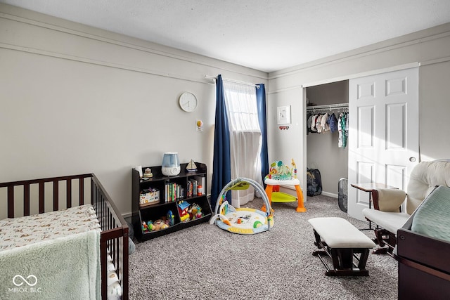 carpeted bedroom with a closet, a crib, a textured ceiling, and baseboards