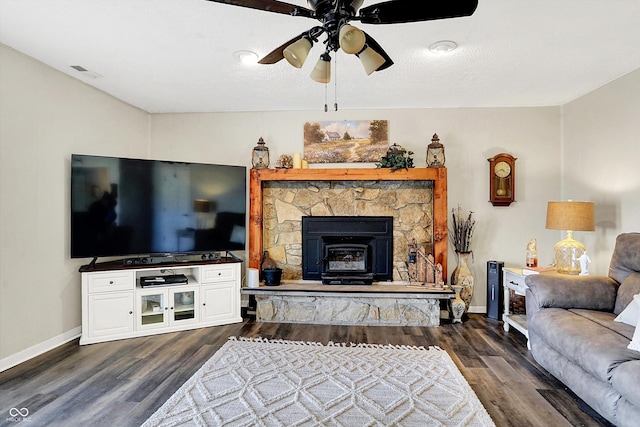 living room featuring dark wood-type flooring, visible vents, baseboards, and ceiling fan