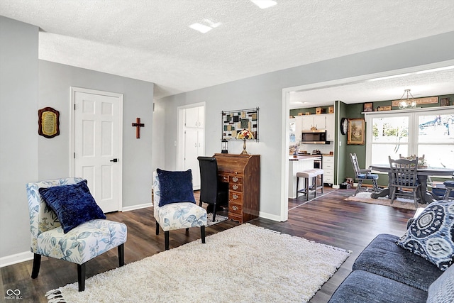 living room featuring baseboards, a textured ceiling, and wood finished floors