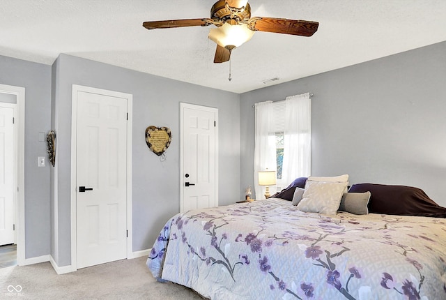 bedroom with light carpet, visible vents, a ceiling fan, and baseboards