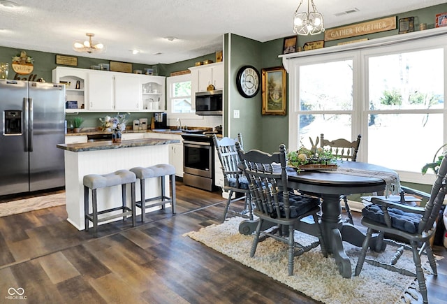 kitchen featuring visible vents, open shelves, a center island, white cabinetry, and stainless steel appliances