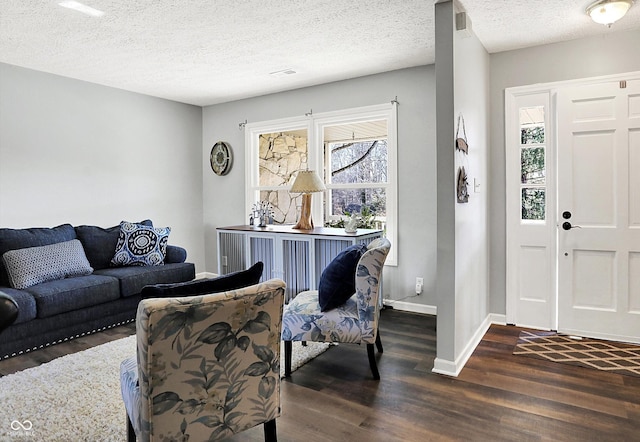 living room featuring a textured ceiling, baseboards, and dark wood-style flooring