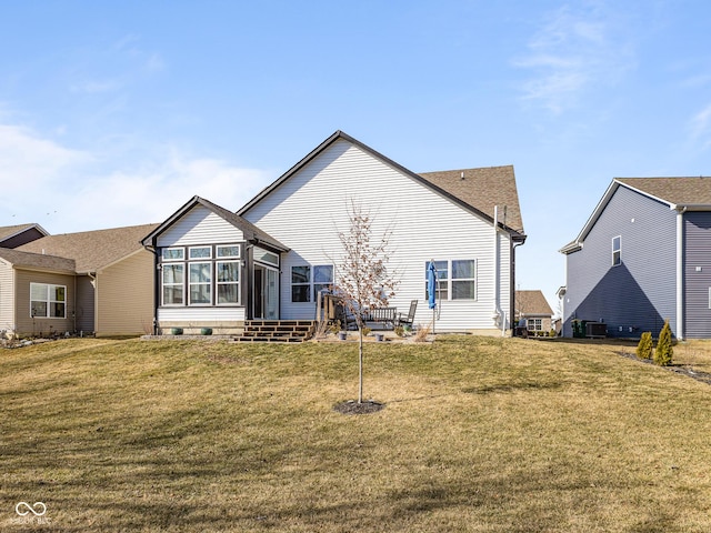 rear view of house with a yard and a sunroom