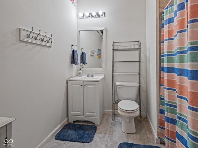 full bath featuring curtained shower, baseboards, toilet, and vanity