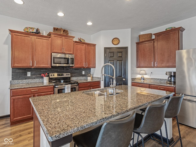 kitchen featuring a sink, a kitchen breakfast bar, light wood-type flooring, and stainless steel appliances