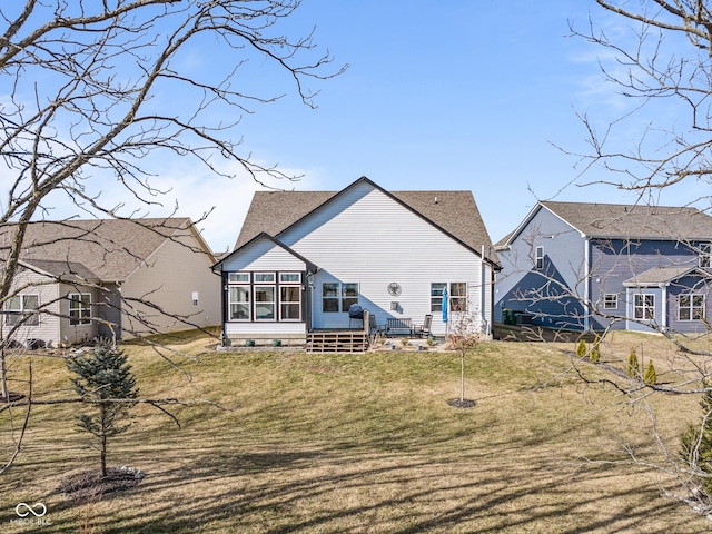 rear view of property with a lawn, a sunroom, and a shingled roof