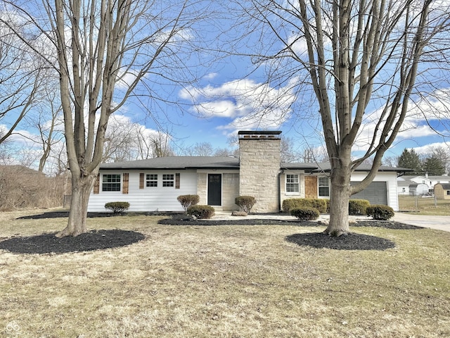 view of front of home with a garage, driveway, and a chimney