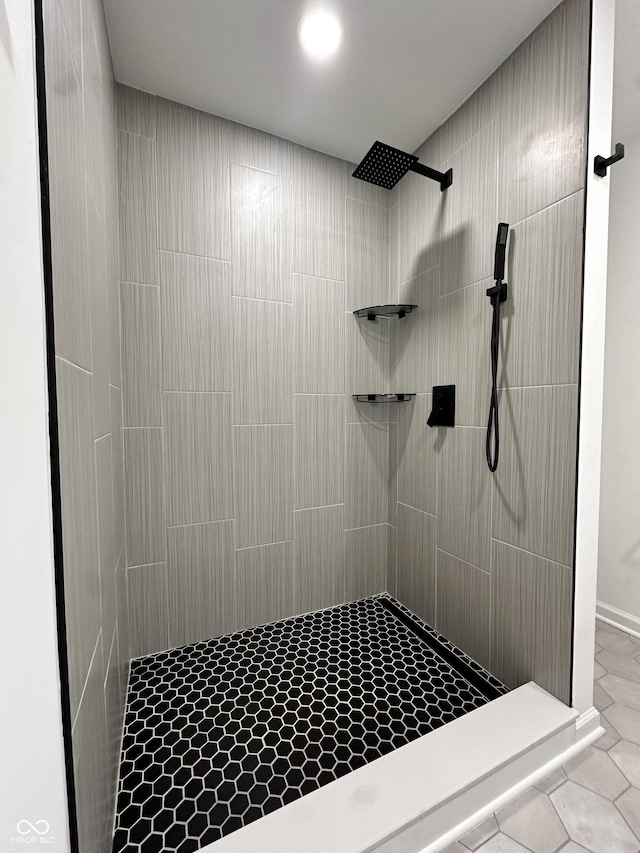 full bath featuring tile patterned floors and tiled shower