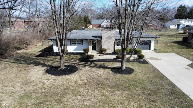 view of front of home featuring a front lawn, driveway, a chimney, and a garage