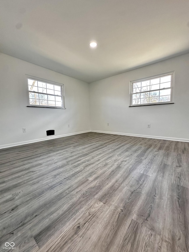 unfurnished room with dark wood finished floors, recessed lighting, and baseboards