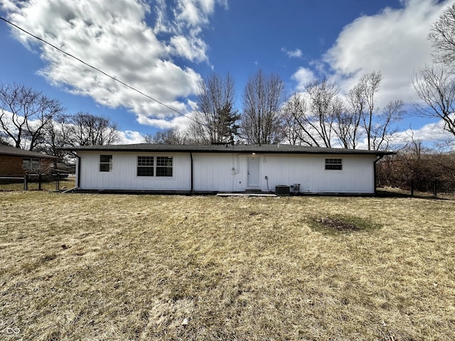 back of property with a lawn and fence