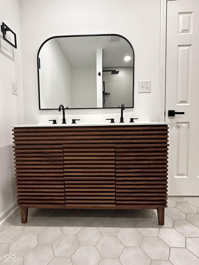 full bathroom featuring tile patterned flooring, double vanity, and a sink