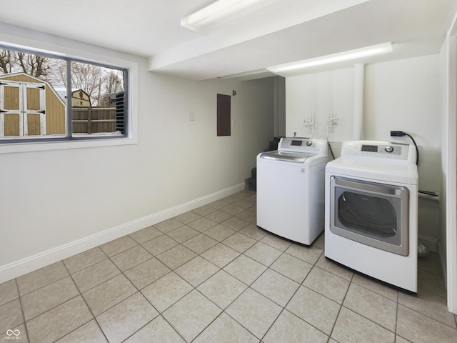 laundry area featuring light tile patterned floors, baseboards, independent washer and dryer, and laundry area