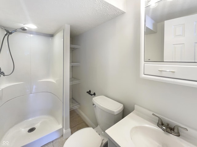 full bathroom with a shower stall, toilet, vanity, tile patterned floors, and a textured ceiling