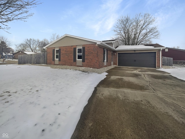 view of front of house featuring brick siding, driveway, a garage, and fence