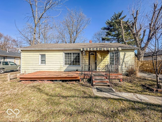 view of front of home with a front lawn, fence, and a wooden deck