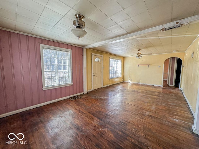 spare room featuring visible vents, arched walkways, wood finished floors, and a ceiling fan