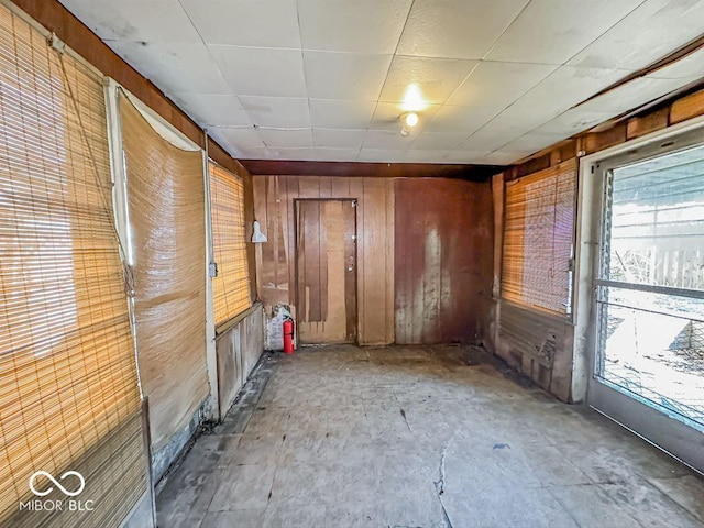 empty room featuring plenty of natural light and wood walls