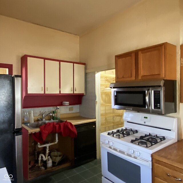 kitchen featuring stainless steel appliances, dark tile patterned floors, and light countertops