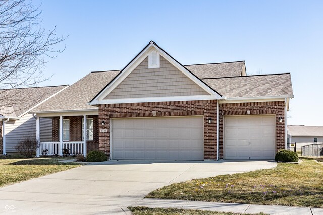 view of front of house with concrete driveway, a garage, brick siding, and roof with shingles