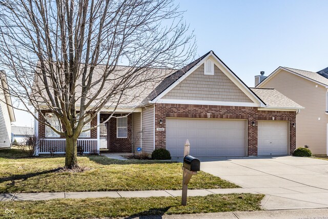 view of front of home featuring a garage, driveway, brick siding, and a front lawn